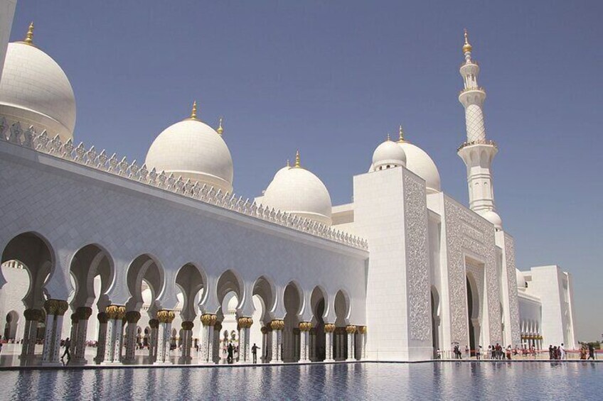 Een grote, witte moskee met meerdere koepels en een hoge minaret. 5