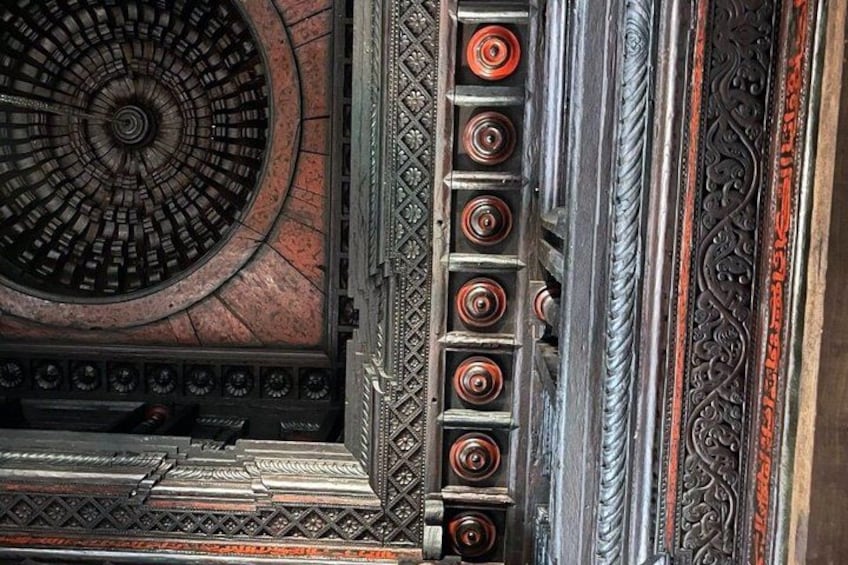 A detailed architectural structure with a circular design, ornate metalwork, and a series of vertical elements. 4