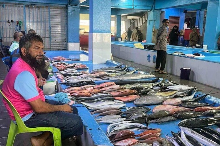 A fish market with various fish displayed on tables. 5