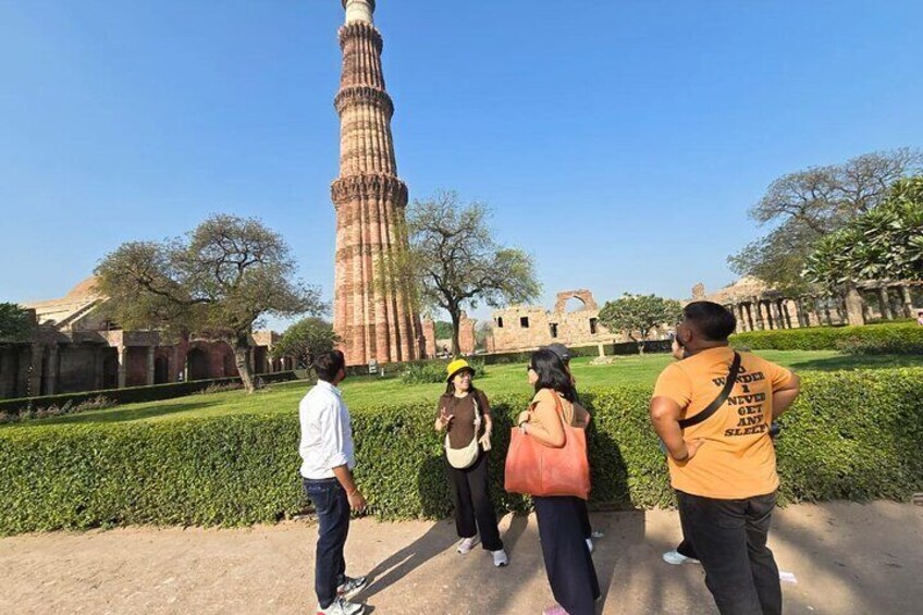 A group of people walking near the Qutub Minar in Delhi. 1