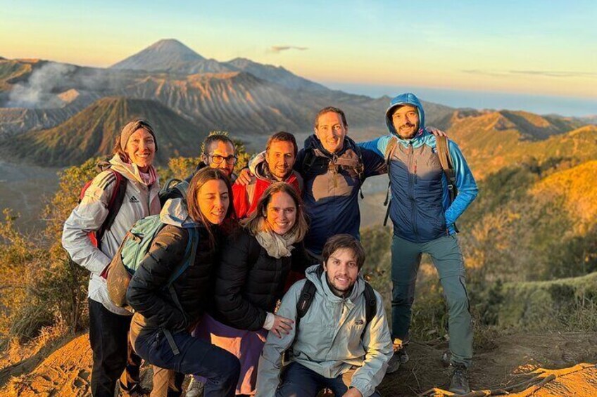 A group of hikers on a mountain trail with a volcano in the background. 3