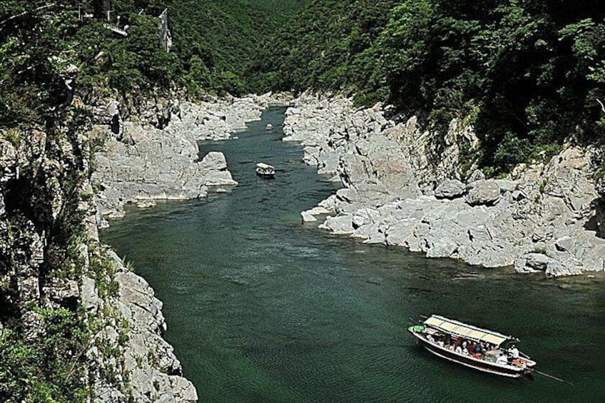Un río con barcos, orillas rocosas y abundante vegetación. 5