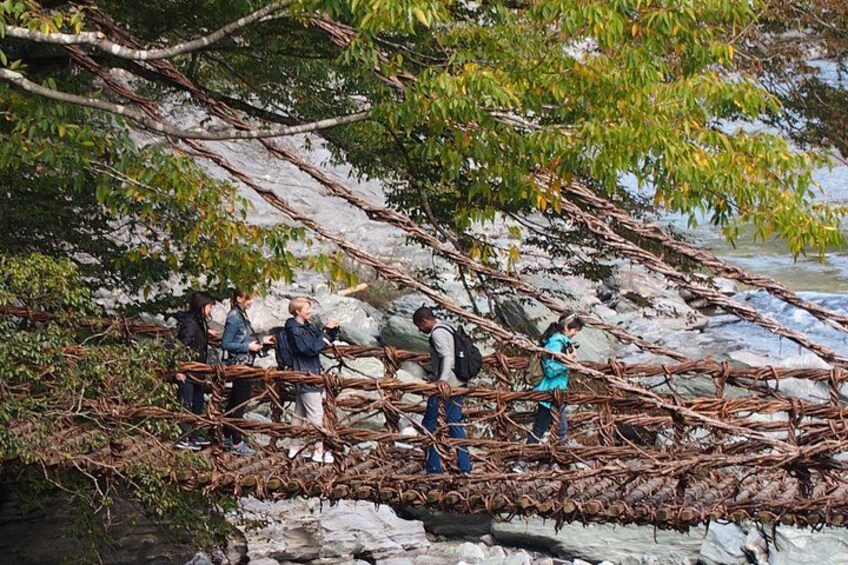 Un grupo de personas cruzando un puente improvisado sobre un arroyo pedregoso. 2