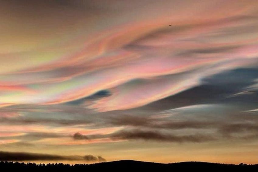 A sunset with colorful clouds over a silhouette of a forest. 4