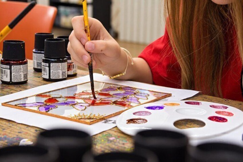 A person painting on a canvas with a palette of colors. 4