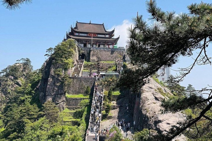 A traditional Chinese building on a mountain with a staircase leading up to it. 3