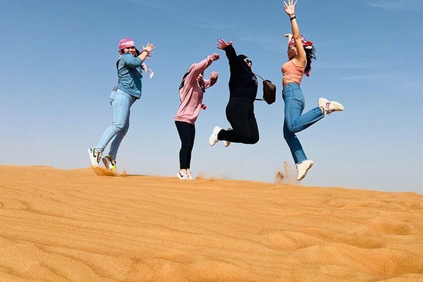 People jumping on a sand dune. 2