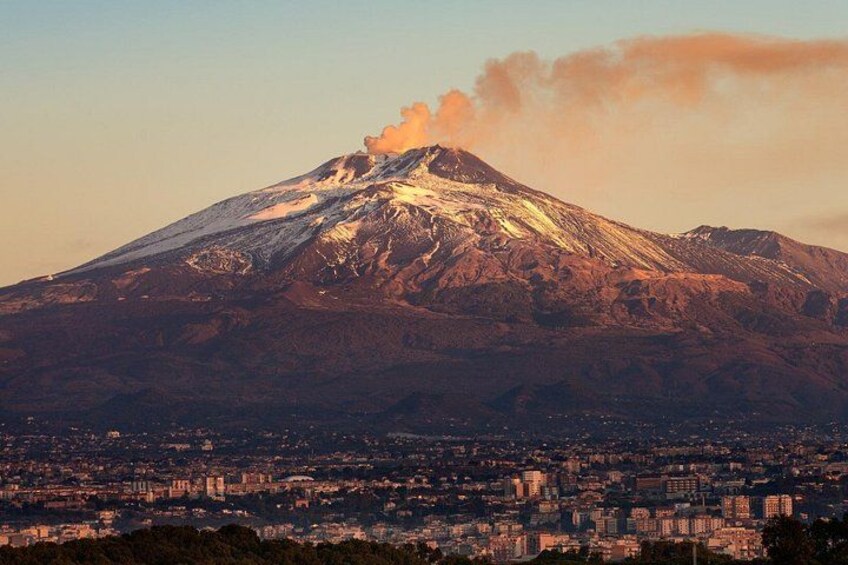 A snow-capped mountain with a cityscape in the foreground. 2