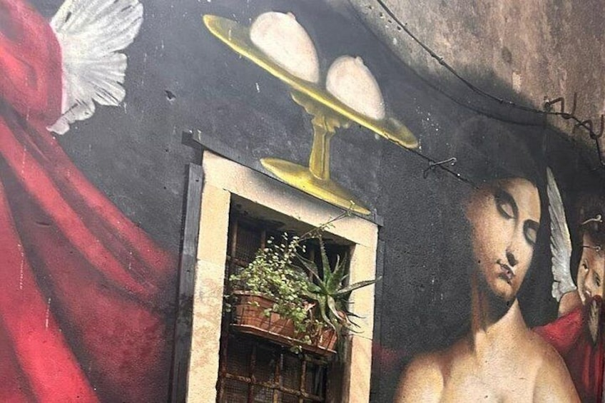 A mural with a woman, a plant, and a golden object. 4