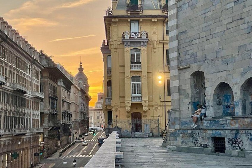 A city street with historic buildings, a domed structure in the distance, and a staircase on the right. 1