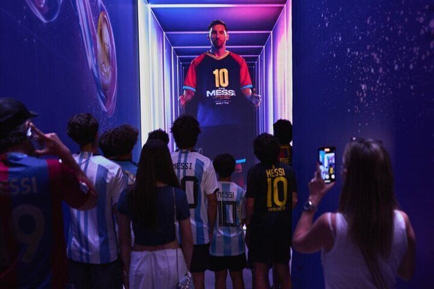 A person in a red and black jersey with the number 10 standing in a corridor. 1