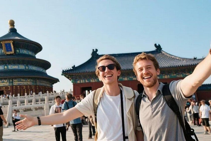 Two people taking a selfie with a traditional Chinese building in the background. 3