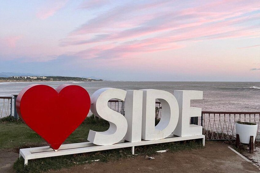 A sign with the word 'SIDE' and a large red heart symbol. 3