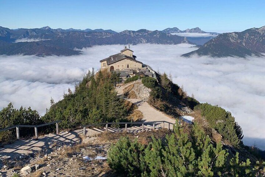 Un albergue de montaña rodeado de bosque y nubes. 1