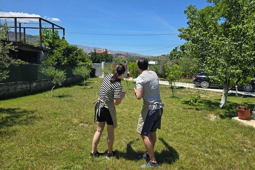 Two people standing on a grassy field with a tree and a car in the background. 2