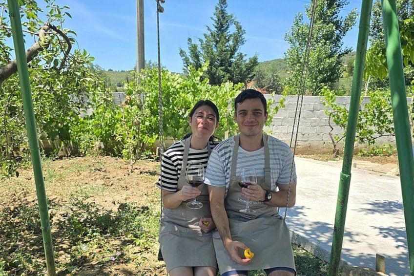 Two people in a vineyard holding glasses of wine. 2