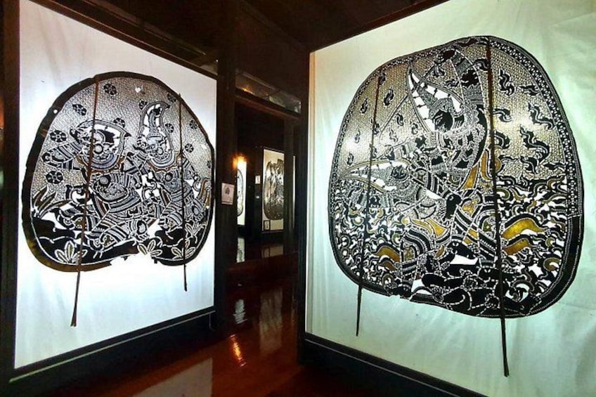 Two large, ornate, black-and-white patterned artworks displayed on walls in a gallery. 3