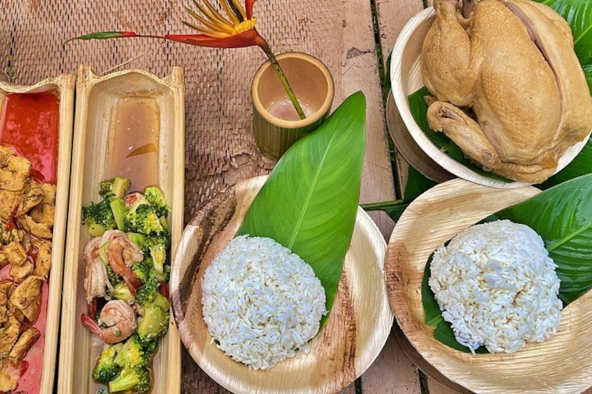 A traditional meal with rice, chicken, and vegetables on a woven mat. 3