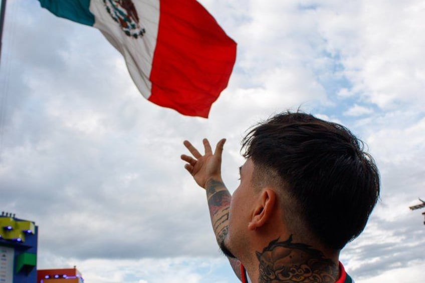 A person with tattoos on their arm and neck, holding a flag. 5
