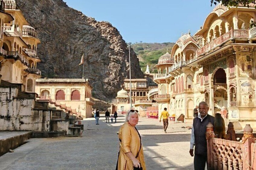 A historic building with intricate architecture, a rocky mountain backdrop, and a clear sky. 4