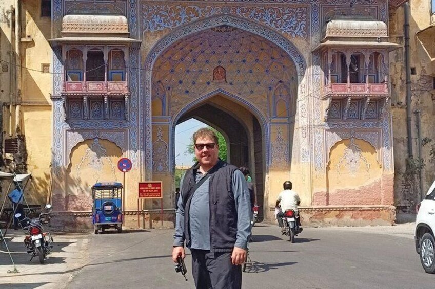 A man standing in front of a large, ornate archway with intricate designs. 3