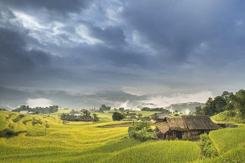 Un paysage rural avec des champs en terrasses, des maisons traditionnelles et un ciel nuageux. 2