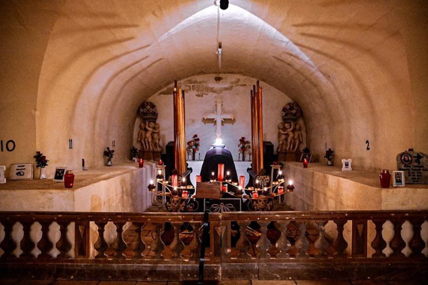An arched interior of a church with a central altar, candles, and religious statues. 2