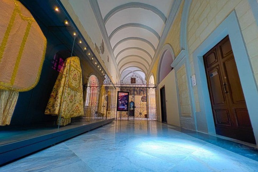 A grand hall with high ceilings, ornate decorations, and a polished floor. 5