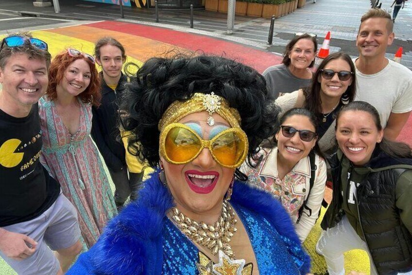 A group of people posing for a photo on a colorful pavement. 1