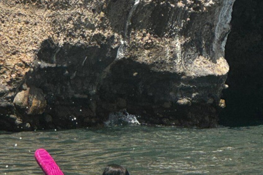 A rocky cliff with water splashing against it. 2