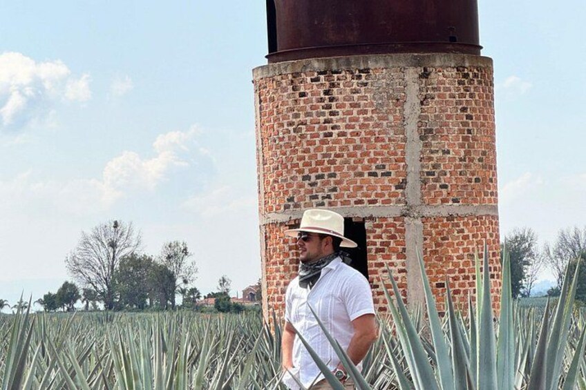 A person standing next to a brick structure with a cylindrical chimney. 3