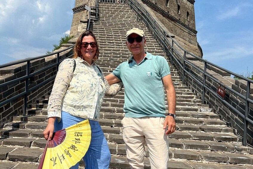 A man and a woman standing on stone steps with a large wall behind them. 3
