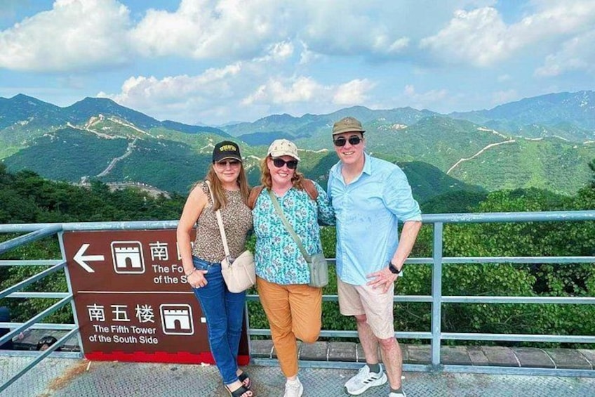 Three people standing in front of a sign with directions to The Fifth Tower of the South Side. 1