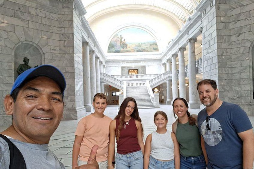 A group of people in a grand building with columns and a large staircase. 5