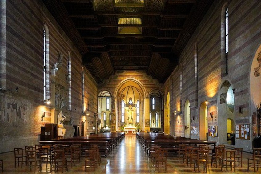 A church interior with rows of wooden pews, arched windows, and a central altar. 5