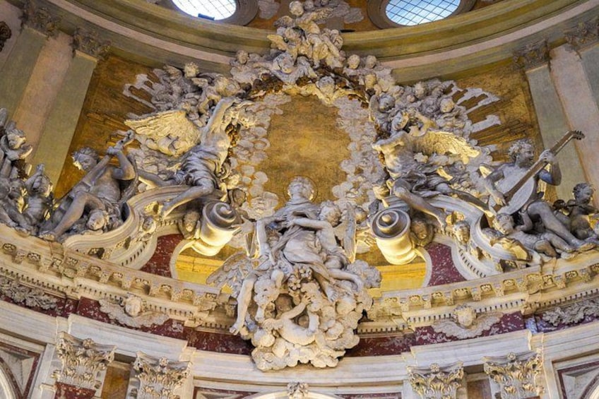 An ornate ceiling with intricate sculptures and gold accents. 3
