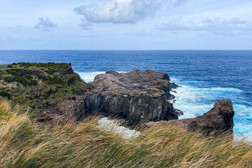 A coastal landscape with rocky cliffs and the ocean. 4
