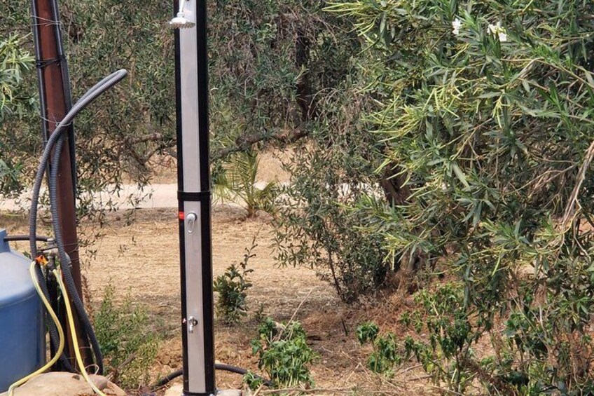A metal structure with cables, surrounded by dry vegetation and a clear sky. 3