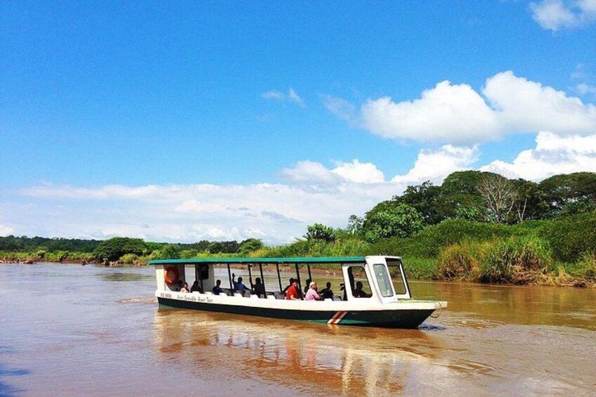 A boat with passengers on a calm river surrounded by greenery. 3