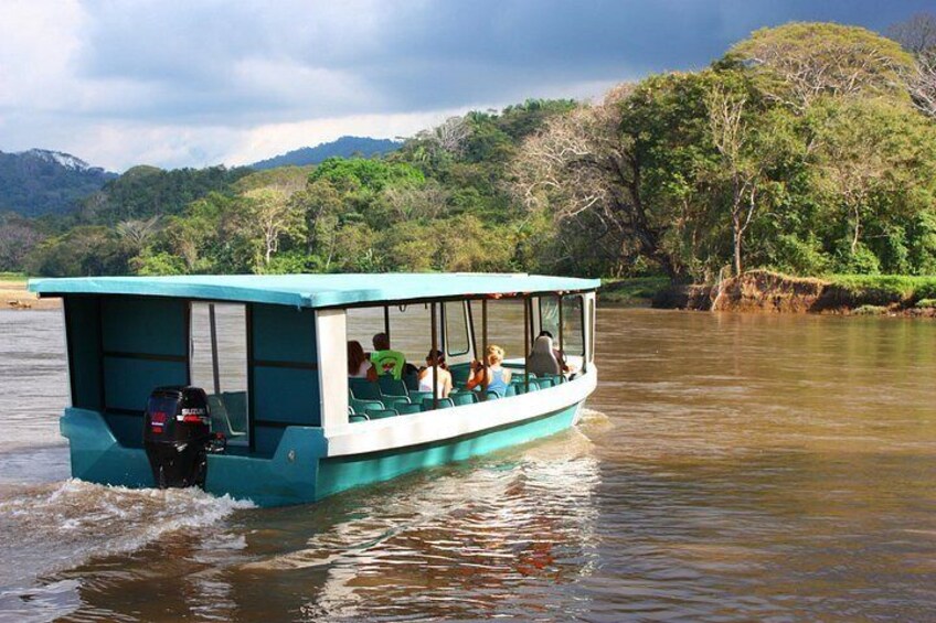 Un bateau transportant des passagers sur une rivière, entouré de verdure et de collines. 3
