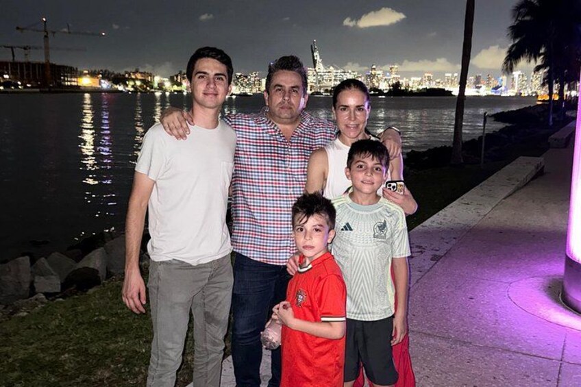 A group of people standing by a waterfront with a city skyline in the background. 3