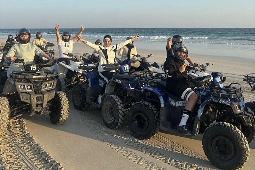 A group of people on ATVs on a beach. 2