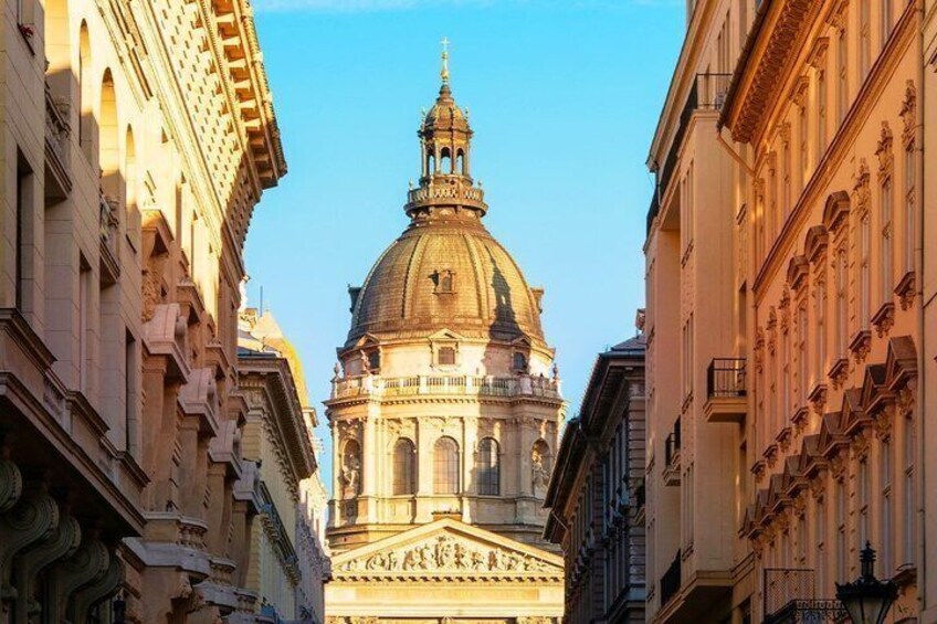 A street leading to a grand building with a large dome and bell tower. 5