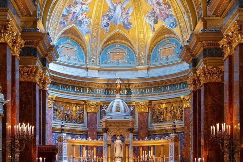 An ornate church interior with a central altar, golden decorations, and a ceiling fresco. 4