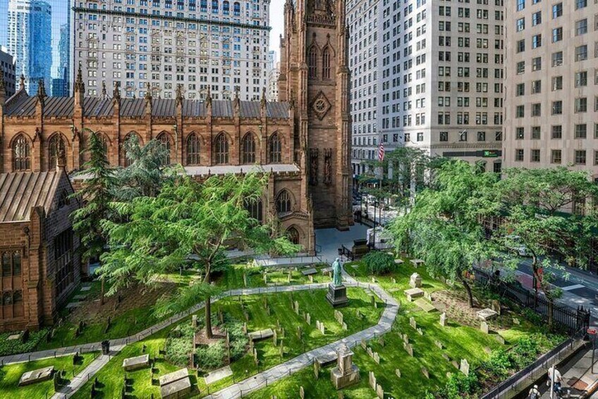 A historic church with a clock tower, surrounded by a cemetery and urban buildings. 3