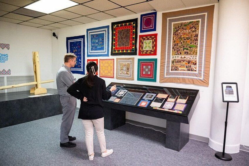 Two people examining a display case with various items. 4