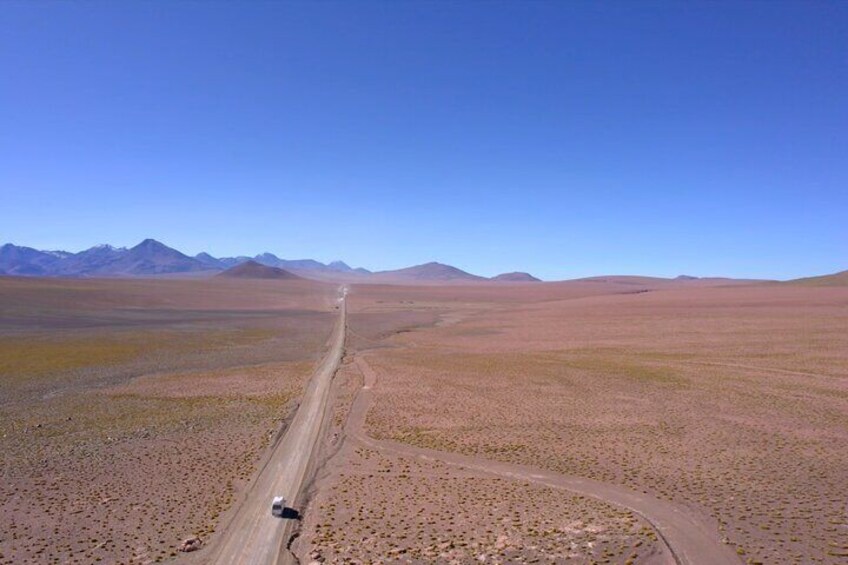 Una strada lunga e dritta in un paesaggio arido, con montagne sullo sfondo. 2