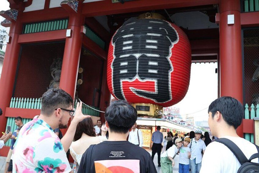 A traditional red gate with a large red lantern hanging above it. 1