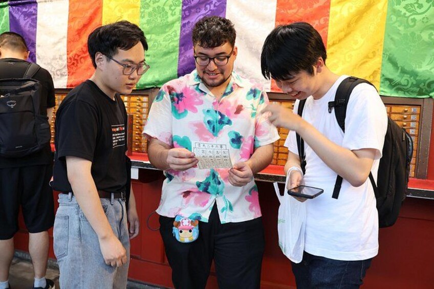 Three people standing in front of a wall with colorful flags. 5