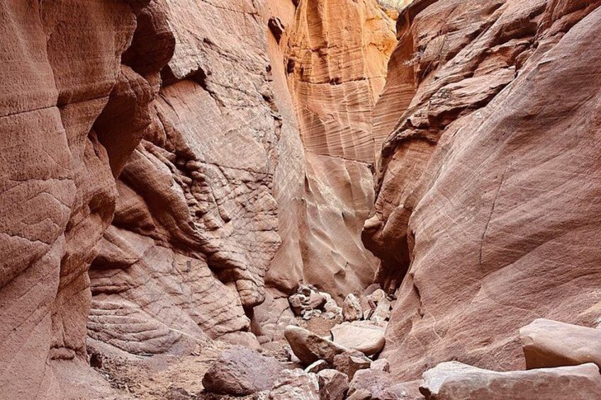 A canyon with layered rock formations and a narrow passage. 3